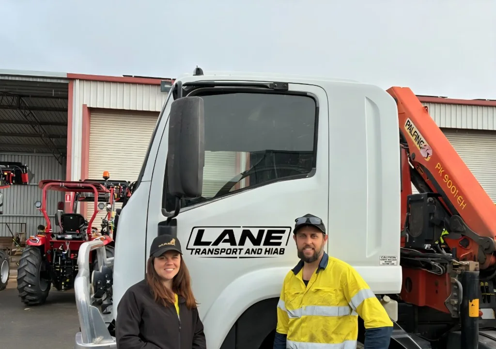 Joel and Jackie standing in front of the Lane Transport hiab truck
