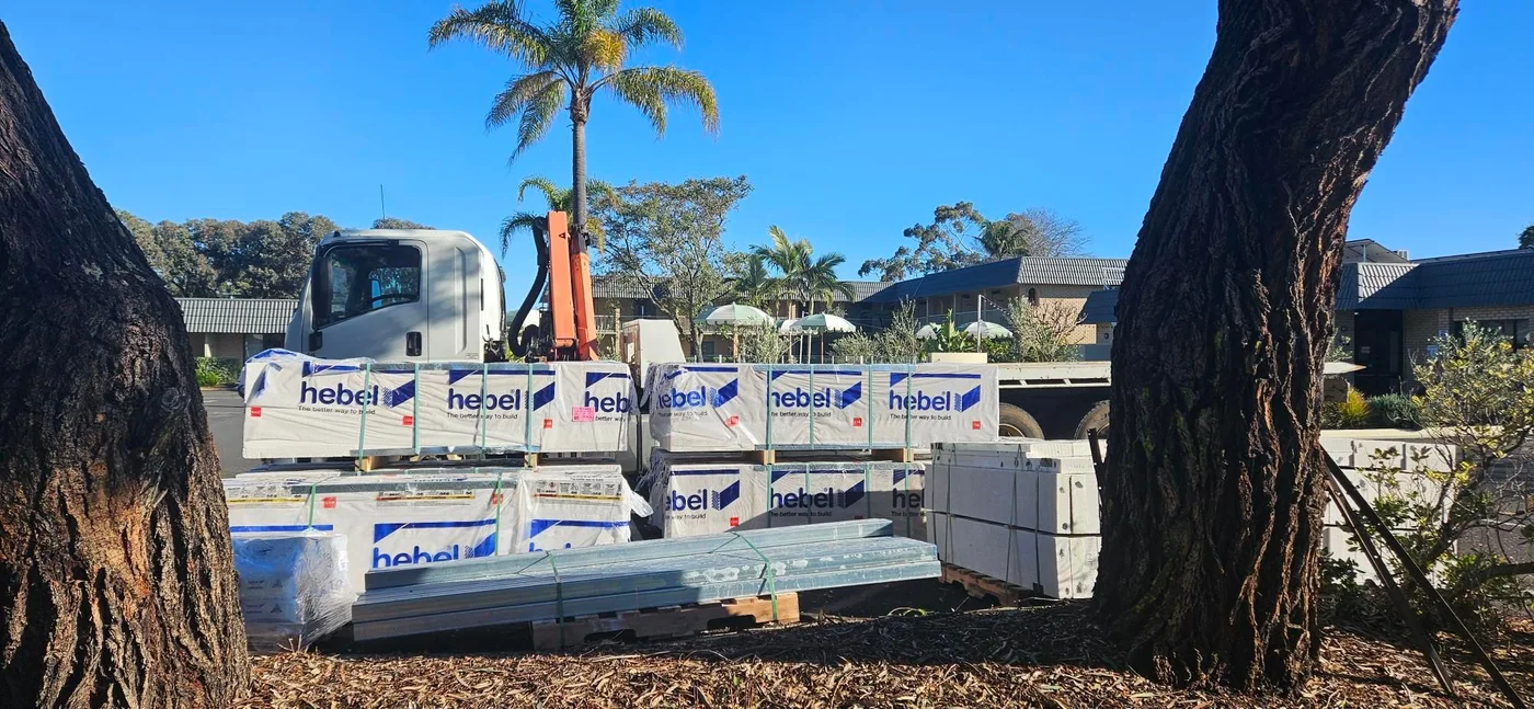 Hiab truck delivering Hebel panels and steel beams to a building site.