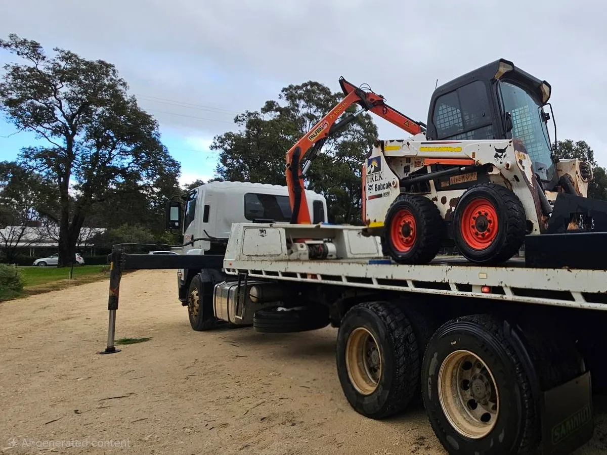 Diagnol back left perspective of a white flat bed hiab transport truck. with supporting legs out, crane extended ready to work, and a bob cat on the flat bed.