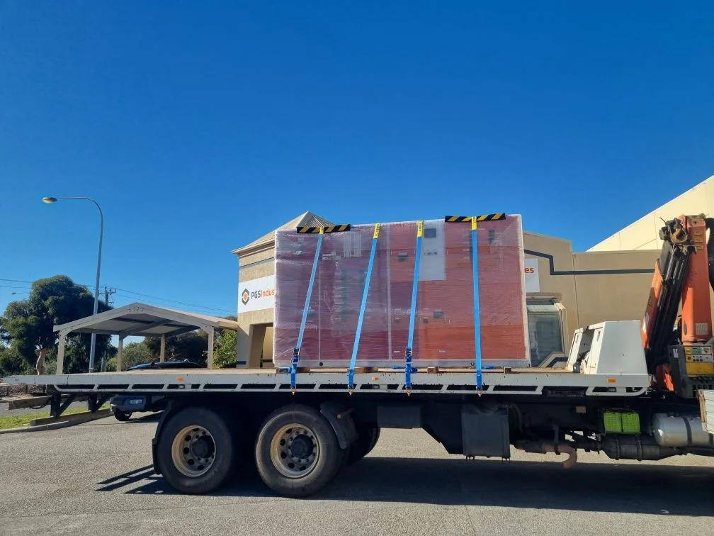 Industrial switchboard secured on a hiab truck with outriggers deployed.