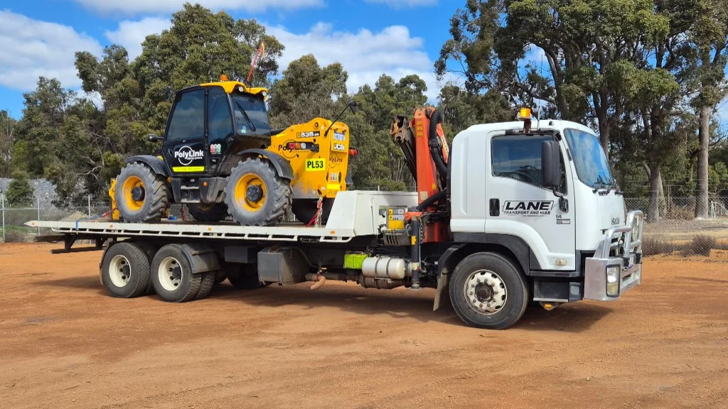 Lane Transport hiab truck loaded with a yellow JCB 535-95 telehandler at a South West yard.